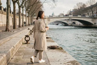 Femme se promenant le long des quais de la Seine à Paris un dimanche matin avec un café à la main