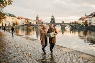 Promenade en couple le long de la Vltava à Prague avec le pont Charles en arrière-plan en automne