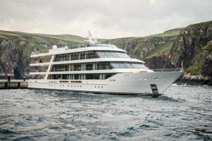 Navire de croisière Uhaina naviguant le long de la côte atlantique rocheuse sous un ciel dégagé